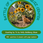 A cat sitting in front of sunflowers on top of a field.