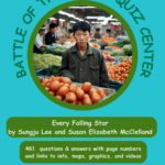 A man standing in front of vegetables and fruit.